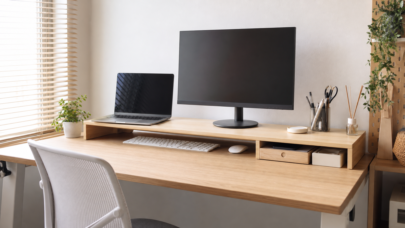 キーボードを下に入れたモニター台でデスクを整えているイメージ